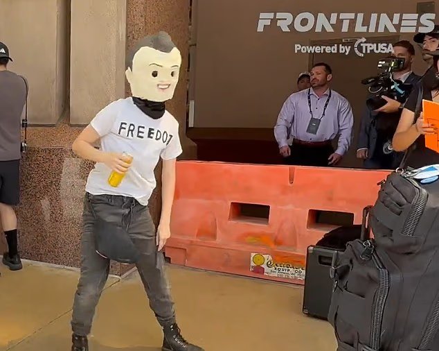 Un manifestant en grève habillé en Charlie Kirk reconstitue son