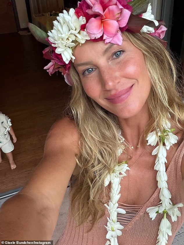Gisele Bundchen, en bikini, tient la main de son fils